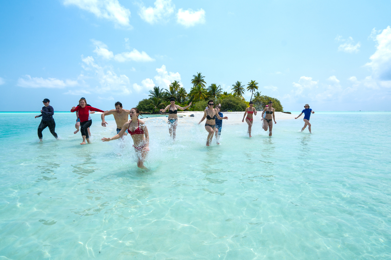 Playa con muchachos disfrutando del mar